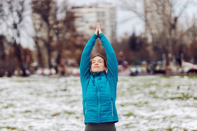 Deportista haciendo ejercicios de fitness en un día nevado de invierno en el parque. Fitness de invierno, nieve, parque