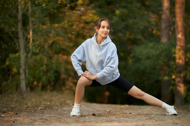 deportista hermosa joven. chica atleta con una sudadera azul, practica deportes.