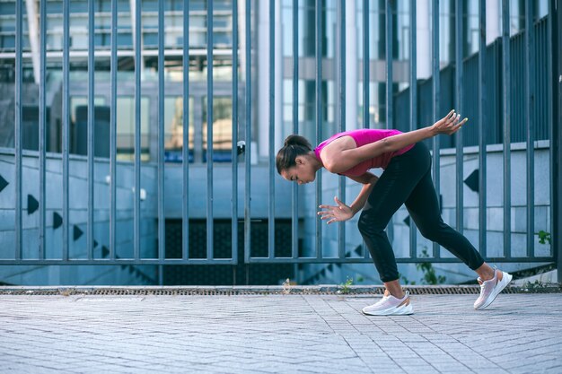 Deportista joven delgada preparándose para correr e inclinando la cabeza hacia abajo. Banner del sitio web