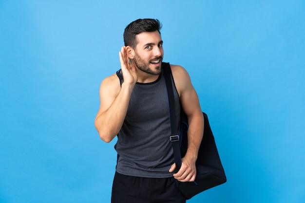 Deportista joven guapo con bolsa de deportes