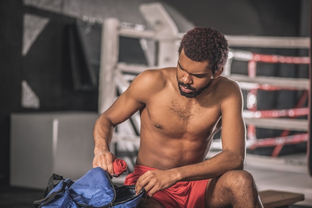 Deportista joven. Joven deportista de piel oscura en un gimnasio preparándose para el entrenamiento