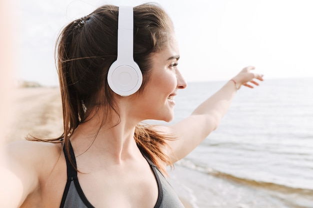 Deportista joven sonriente con auriculares