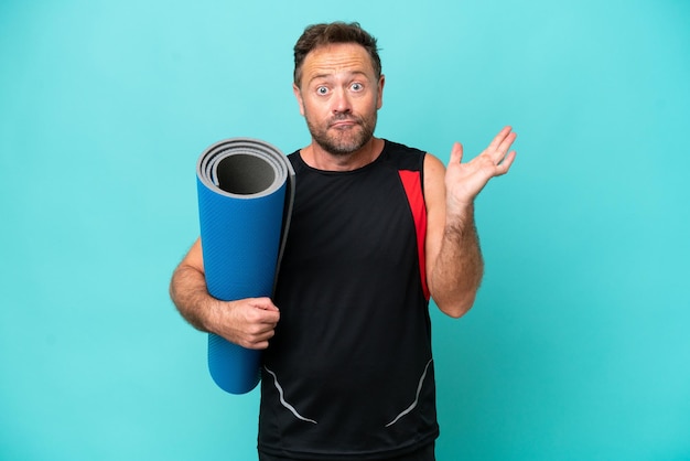 Deportista de mediana edad yendo a clases de yoga mientras sostiene una colchoneta