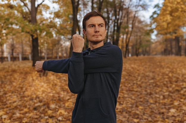 deportista motivado estirando los brazos y calentándose mientras hace ejercicio durante el entrenamiento