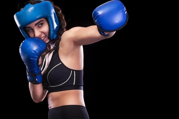 Deportista muay thai boxeador luchando aislado en el fondo negro espacio de copia