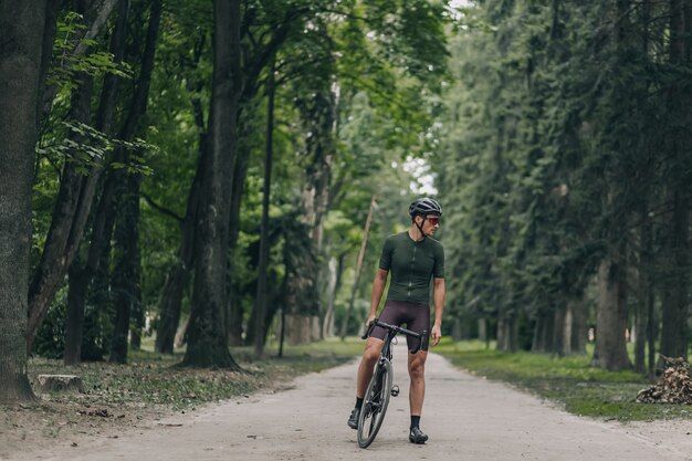 Deportista musculoso tomando un descanso después de un paseo en bicicleta