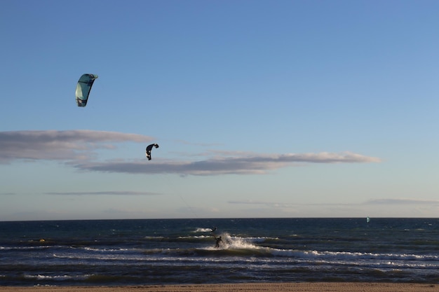 Deportista practicando kitesurf en el mar al atardecer