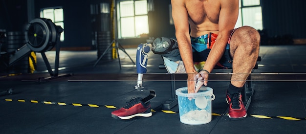 Deportista con prótesis trabajando en gimnasio