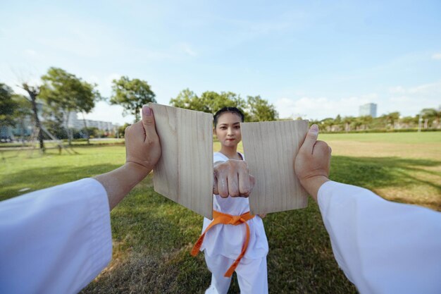 Foto deportista rompiendo una tabla de madera