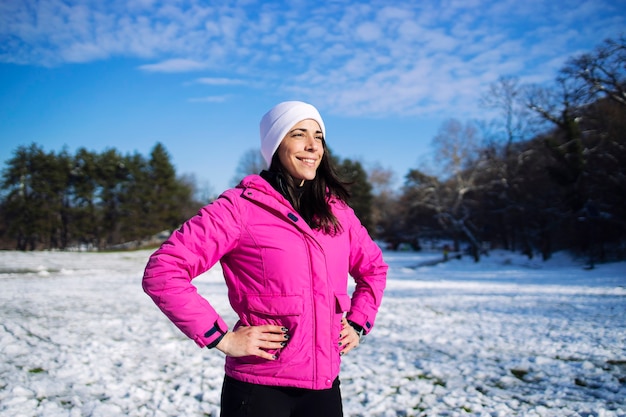 Deportista en ropa de entrenamiento de invierno a punto de comenzar a correr entrenando en la nieve.