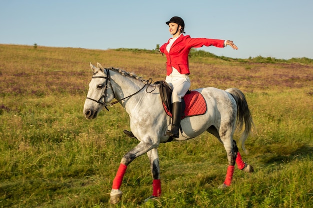 La deportista sobre un caballo. La amazona sobre un caballo rojo. Equitación. Carreras de equitación. Jinete sobre un caballo.