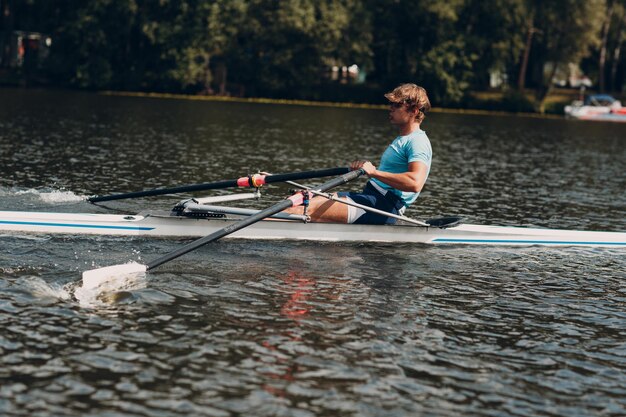 Deportista solo hombre remero remando en barco