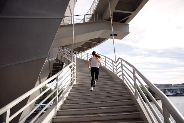 Deportista subiendo las escaleras al atardecer