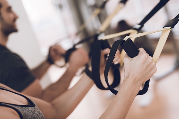 Los deportistas están en el gimnasio y se centran en los ejercicios.