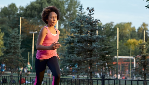 Deportiva chica afroamericana corriendo en la calle