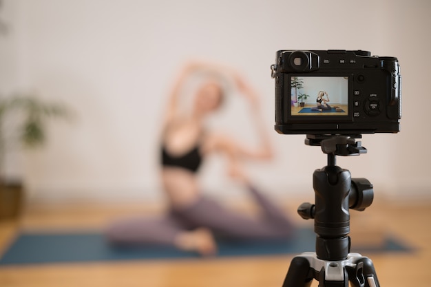 Deportiva joven haciendo práctica de yoga en una pared blanca con plantas - concepto de vida sana y equilibrio natural entre el cuerpo y el desarrollo mental