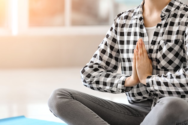 Deportiva joven practicando yoga en casa