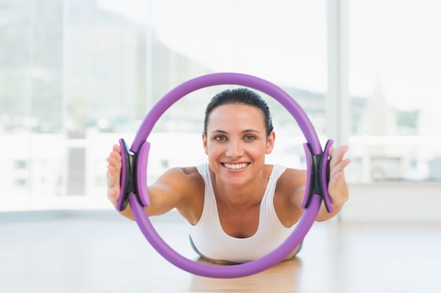 Deportiva mujer con anillo de ejercicios en el gimnasio