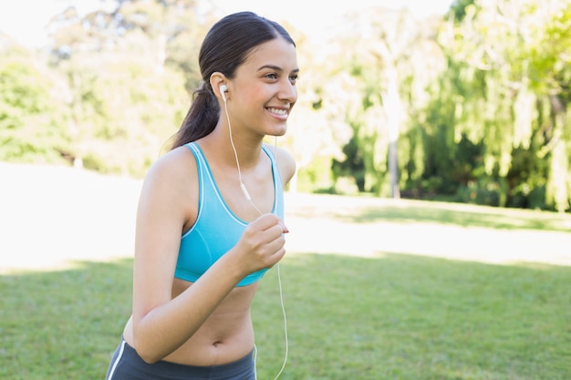 Deportiva mujer corriendo mientras escucha música