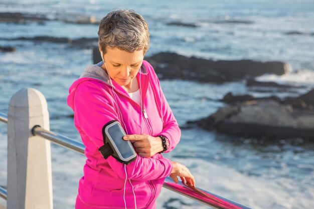 Foto deportiva mujer escuchando música a través de auriculares