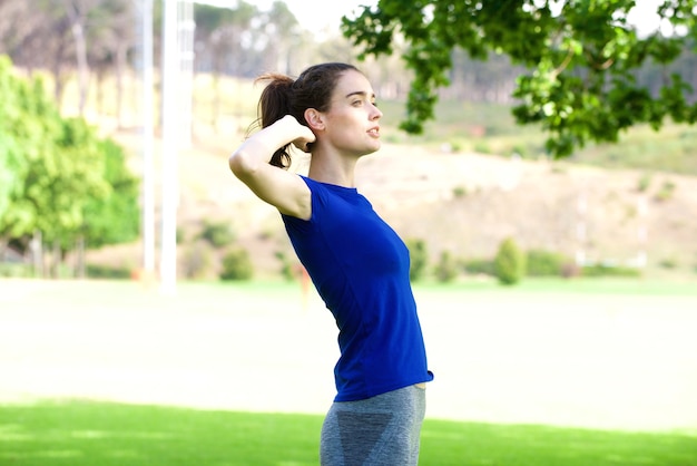 Deportiva mujer estirando al aire libre