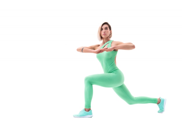 Deportiva mujer estirando sobre fondo blanco