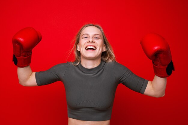 Deportiva mujer joven en guantes de boxeo rojos está jugando