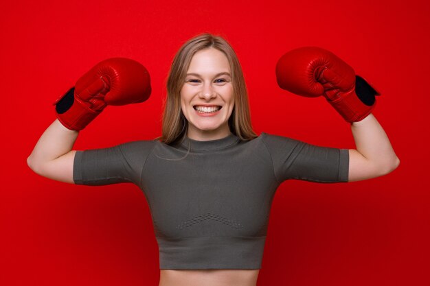 Deportiva mujer joven posando en guantes de boxeo