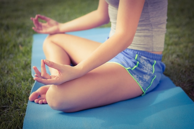 Deportiva mujer meditando sobre colchoneta