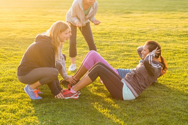 Deportivas mujeres haciendo sentadillas durante la clase de fitness