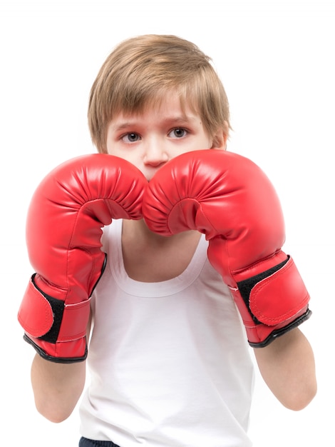 Deportivo y fuerte boxeo infantil en guantes rojos y camiseta blanca