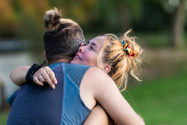 Deportivo, hombre y mujer, se abrazar, en, un, parque