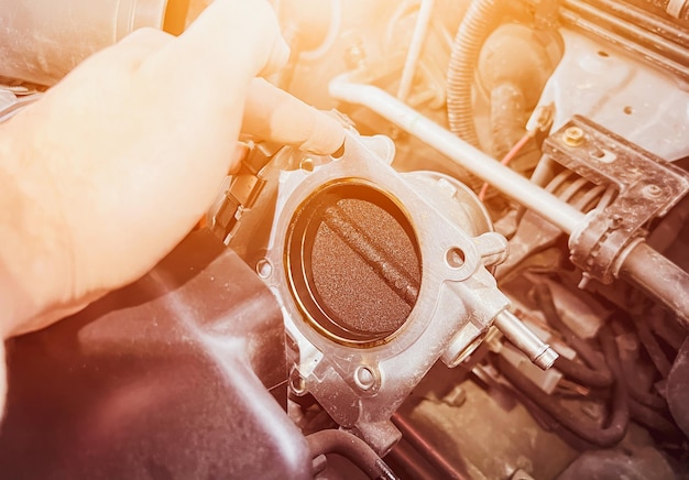 Foto los depósitos de carbono dañan una pala del cuerpo del acelerador y está cubierta de suciedad y carbono que deteriora el rendimiento y la eficiencia del motor. la entrada de aire está restringida y la rpm al ralentí es inestable.