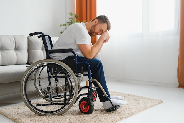 Depresión y soledad en hombre discapacitado Anciano en silla de ruedas llorando en interiores