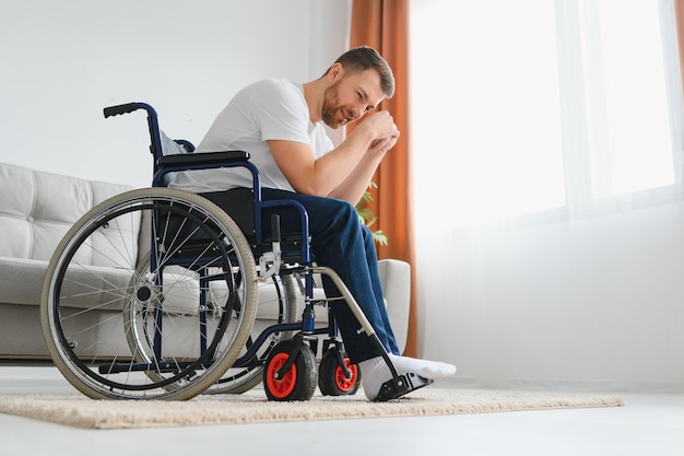 Depresión y soledad en hombre discapacitado Anciano en silla de ruedas llorando en interiores