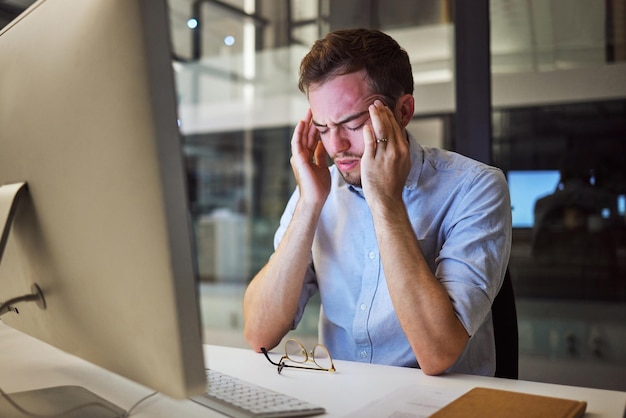 Foto depressão de estresse e saúde mental para empresário noturno sentado em sua mesa de computador com ansiedade de dor de cabeça e esgotamento da pressão de trabalho homem estressado trabalhando até tarde em seu escritório na austrália