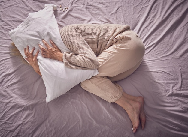 Depressão de vista superior e mulher triste com quarto de travesseiro e insônia problema de ansiedade e choro Senhora cansada e doente deprimida em noite sem dormir medo e estresse de saúde mental com medo e esgotamento