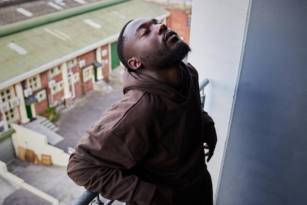 Depressionen, psychische Gesundheit und Angstzustände für traurige Menschen, die auf dem Balkon der Wohnung unter Lebensproblemen leiden