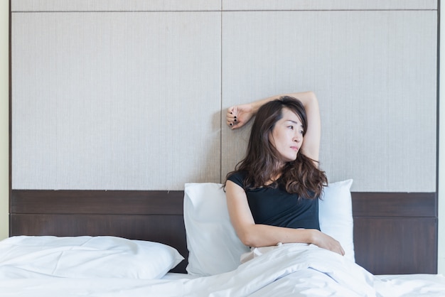 Depressive Frau sitzt auf dem Bett