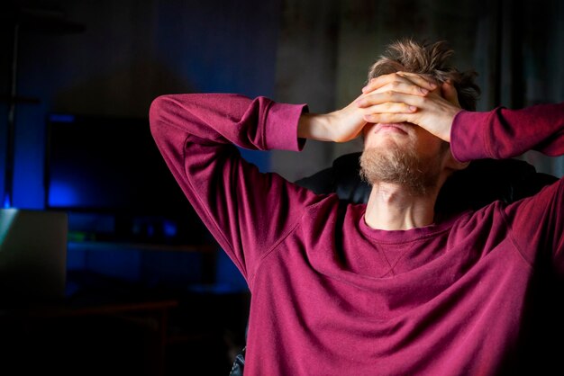 Foto depressiver student bedeckt gesicht mit handfläche und sitzt nachts auf einem stuhl b