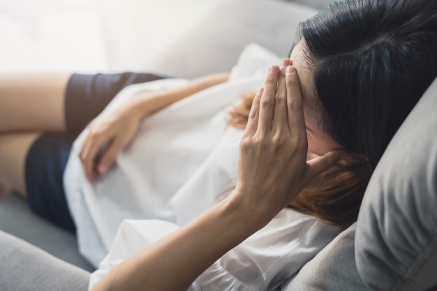 Deprimierte junge Frau, die Hand auf Kopf hält