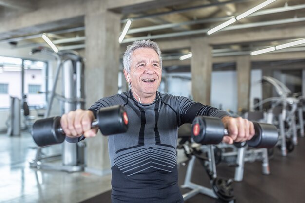 Der 60-jährige Mann genießt das Hanteltraining im Fitnesscenter.