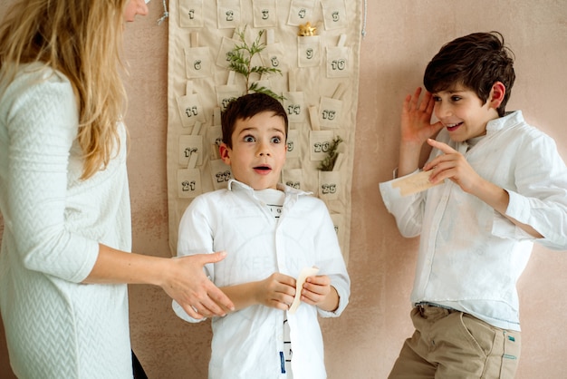 Der Adventskalender hängt an der Wand. Geschenke Überraschungen für Kinder. zwei emotionale Jungs