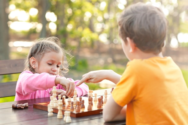 Der ältere Bruder bringt seiner jüngeren Schwester das Schachspielen bei