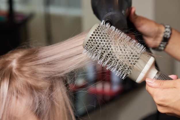 Der Airtouch-Haarstylist macht mit dem Kamm auf dünnen Strähnen die Shatush-Technik zum Aufhellen der Haare voluminös