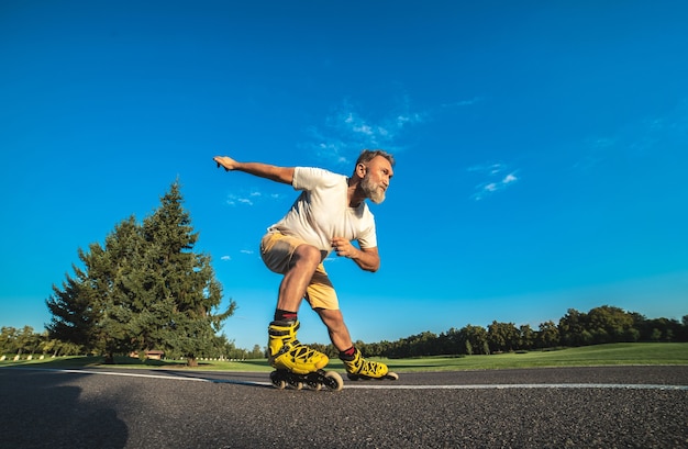 Foto der alte mann beim rollerblading auf der straße