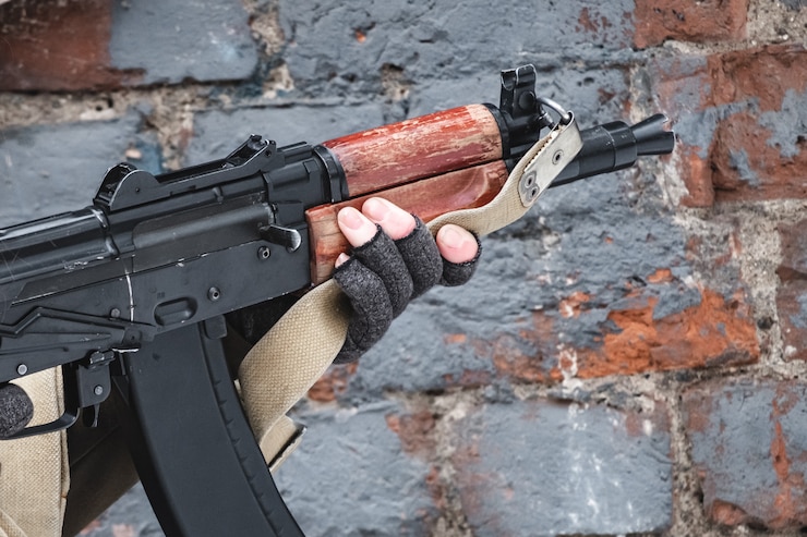 Foto der angeheuerte soldat zielt von einem modernen gewehr in der nähe einer mauer ab.