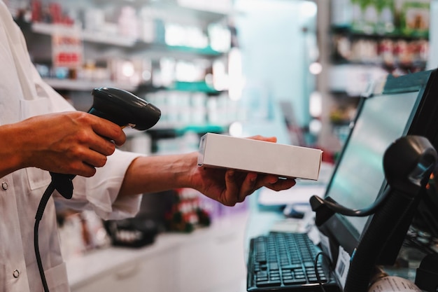 Der Apotheker verwendet einen Barcodeleser, um ein Medikament zu identifizieren und zu verkaufen