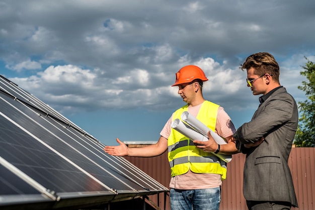 Der Arbeiter erklärt seinem Chef, wie die Installation von Sonnenkollektoren