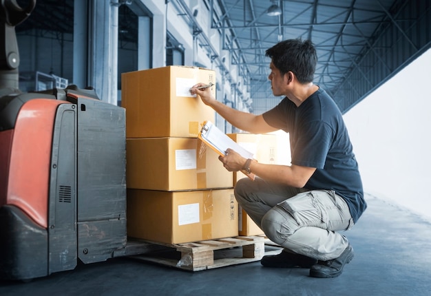 Der Arbeiter führt die Bestandsverwaltung von Paketkisten durch